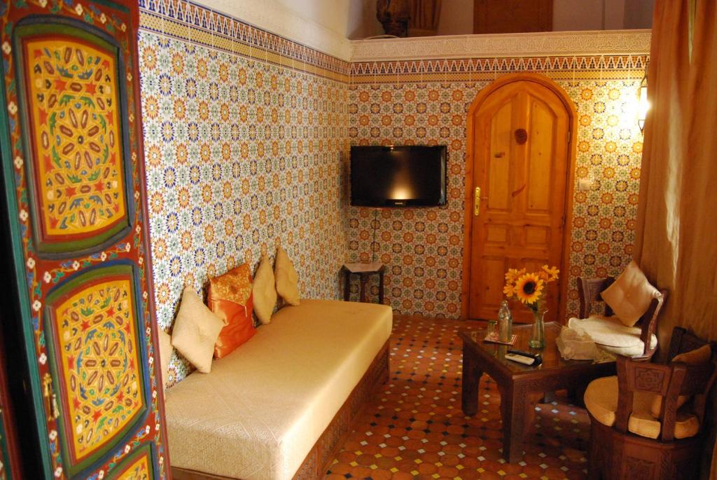 a living room with a couch and a tv at Riad Dar Zouhour in Rabat