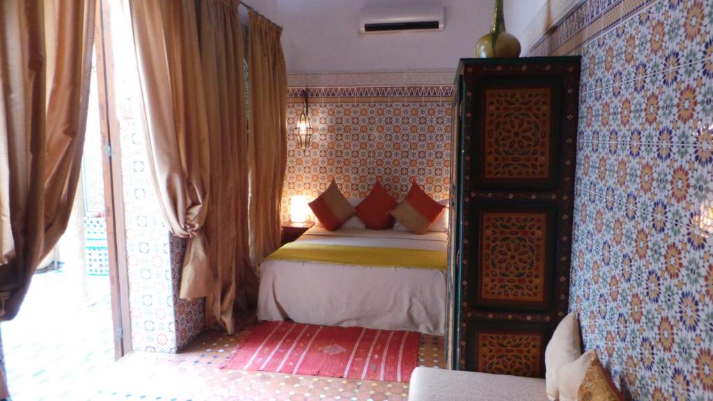 a bedroom with a bed with red pillows at Riad Dar Zouhour in Rabat