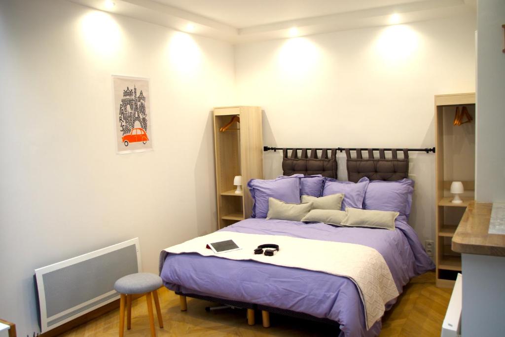 um quarto com uma cama roxa e um banco em Le Poissonnière em Paris
