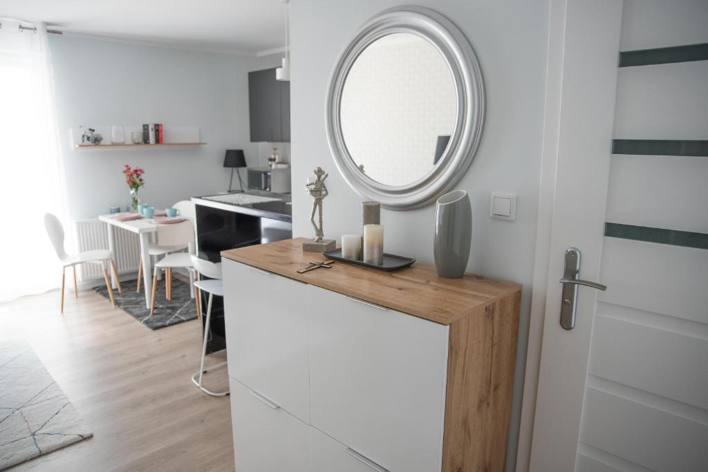 a white kitchen with a mirror and a table at Apartament Soft 11 in Biała Podlaska