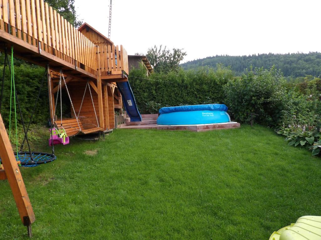 a backyard with a blue trampoline in the grass at Domek nad Potokiem in Słotwiny