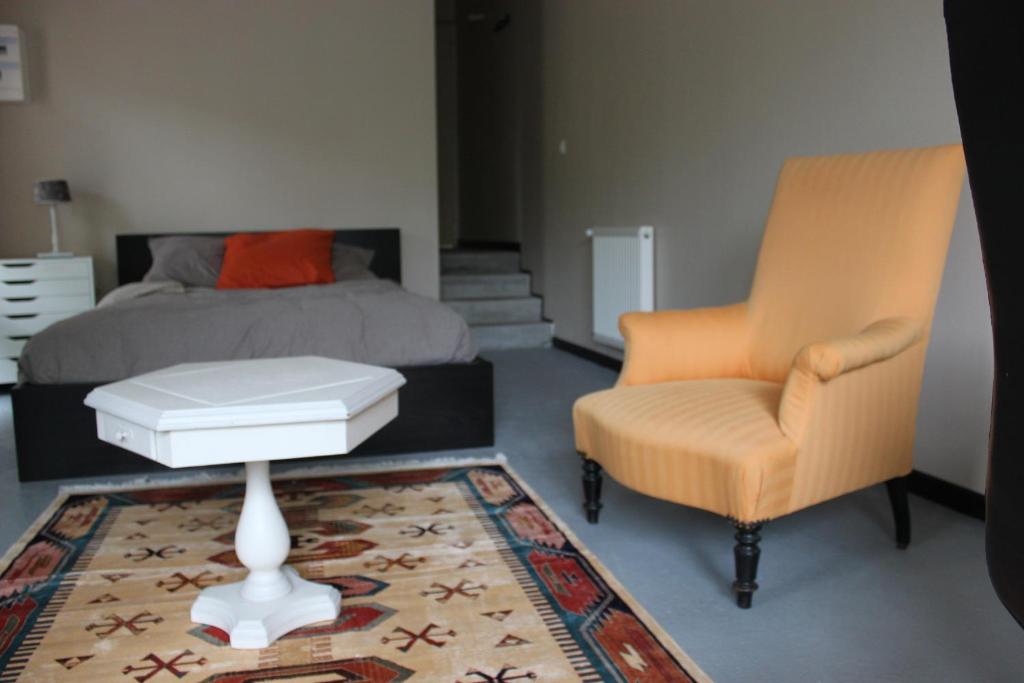 ナントにあるLa Tropicale- Chambre d'hôte au calmeのベッドルーム1室(ベッド1台、テーブル、椅子付)