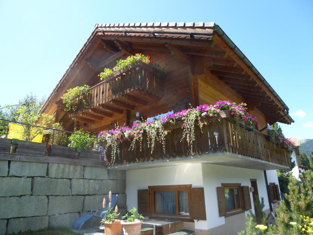 a house with a balcony with flowers on it at Apartment Fadail 2B in Lenzerheide