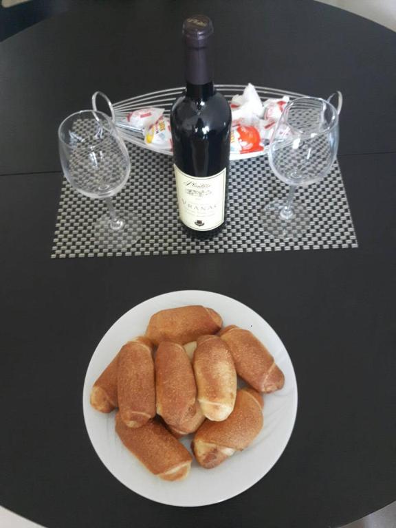 a plate of bread on a table with a bottle of wine at Minka in Kotor