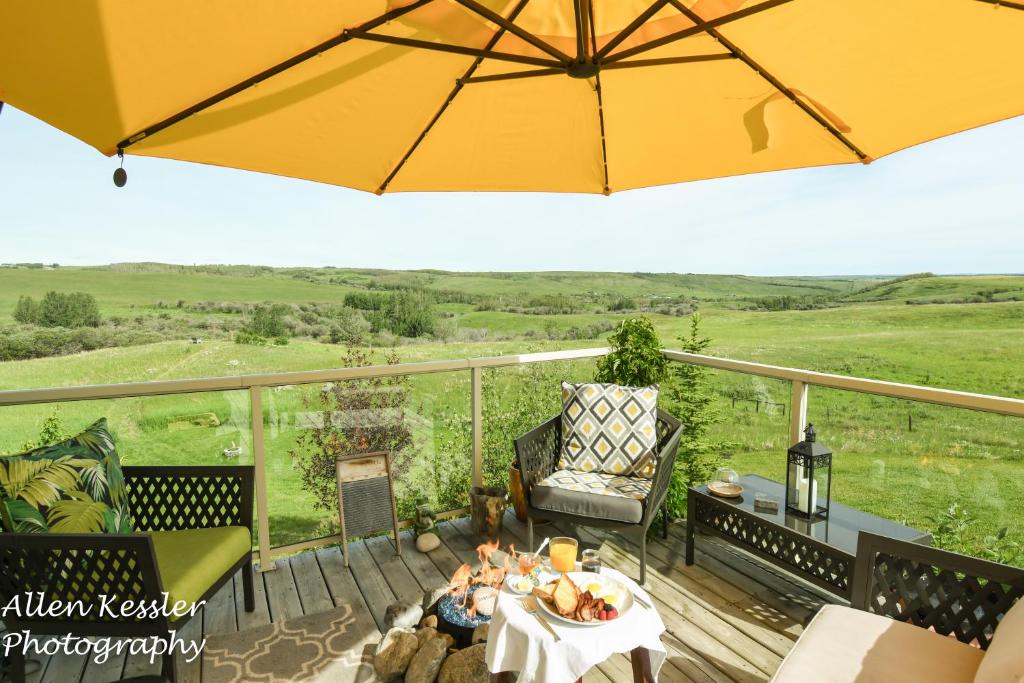 a patio with an umbrella and a table and chairs at Misty Ridge Retreat B&B in Foothills