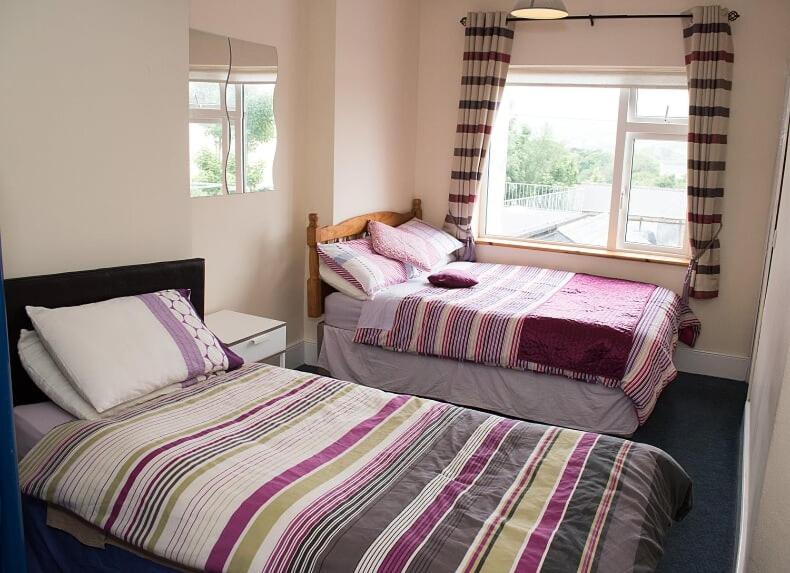a bedroom with two beds and a window at Sive Budget Accommodation in Cahersiveen