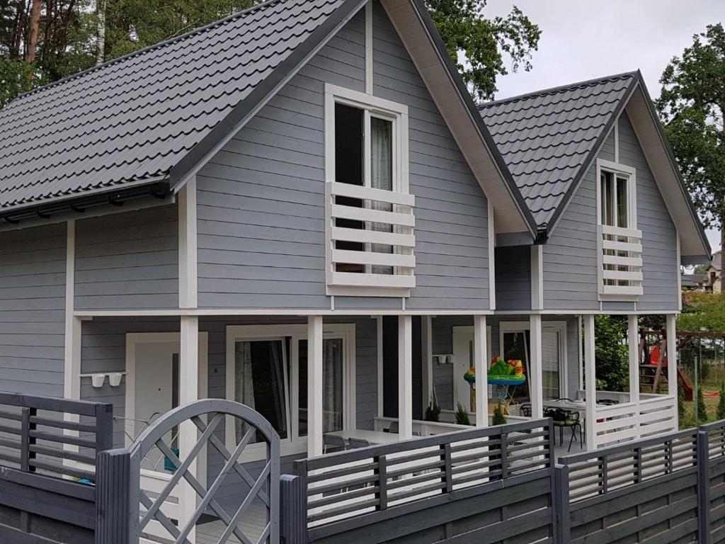 a house with a gray roof and a porch at Pobierowo Bracka 1 in Pobierowo