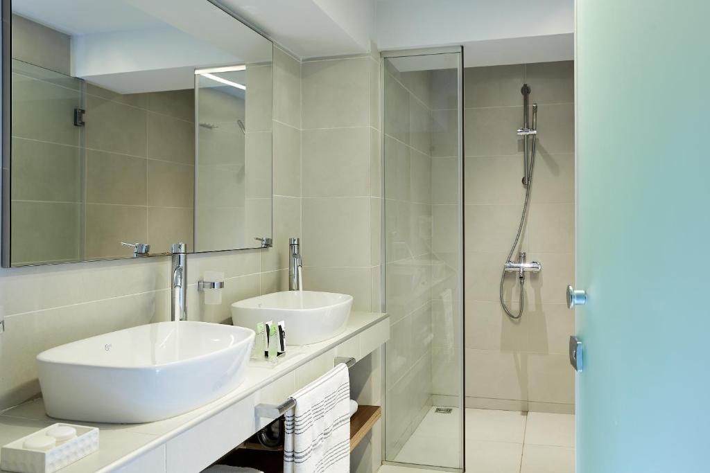 a bathroom with two sinks and a glass shower at Makryammos in Limenas