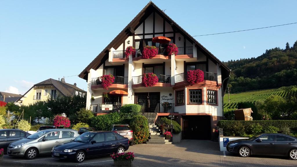 a building with cars parked in a parking lot at Haus Weingarten APPARTEMENTS-ZIMMER in Ernst