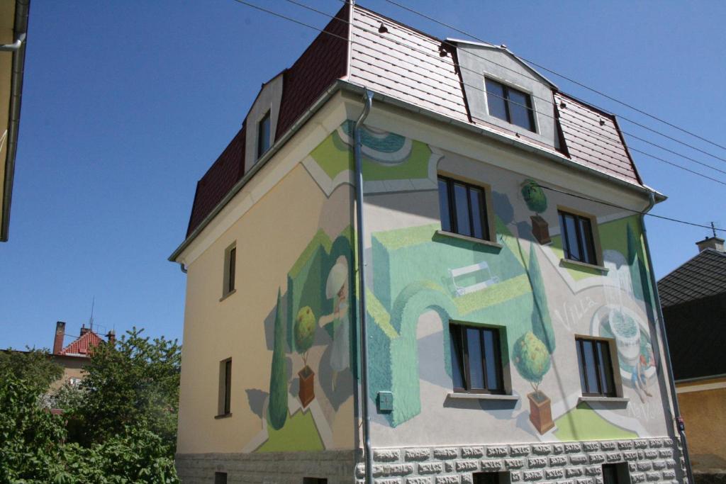 a building with a painting on the side of it at Hotel Na Vodách in Mariánské Lázně