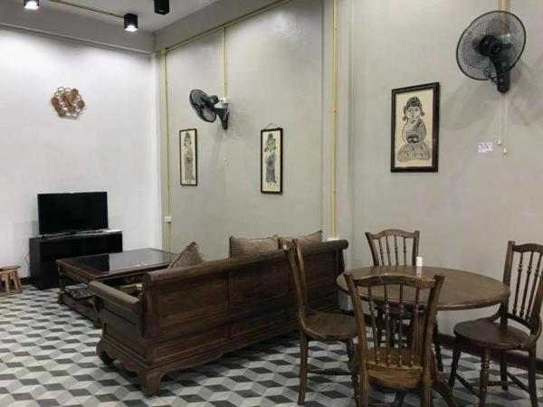 un soggiorno con divano, tavolo e sedie di Chato Hostel a Pakse