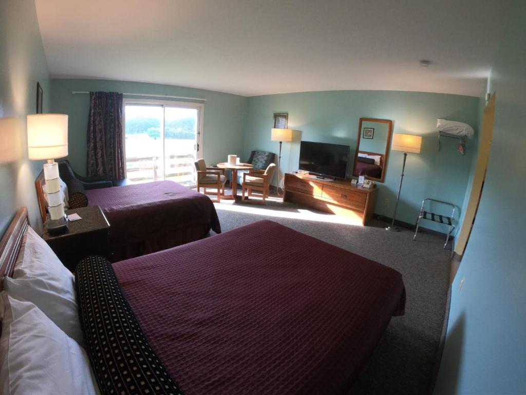 a hotel room with two beds and a living room at Copper Lantern Motor Lodge in West Brookfield