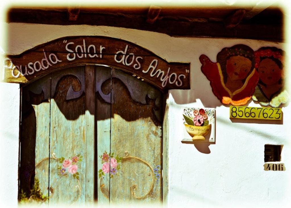 una puerta vieja con un cartel en un edificio en Pousada Solar dos Anjos, en Lavras Novas