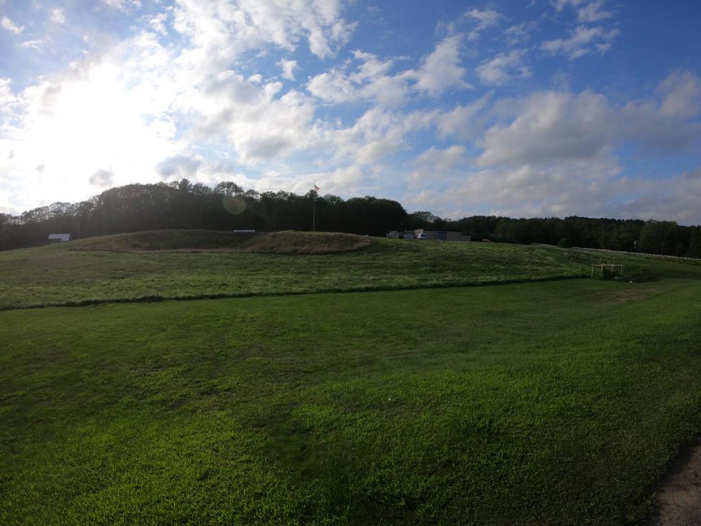 a large green field with the sun in the sky at Copper Lantern Motor Lodge in West Brookfield