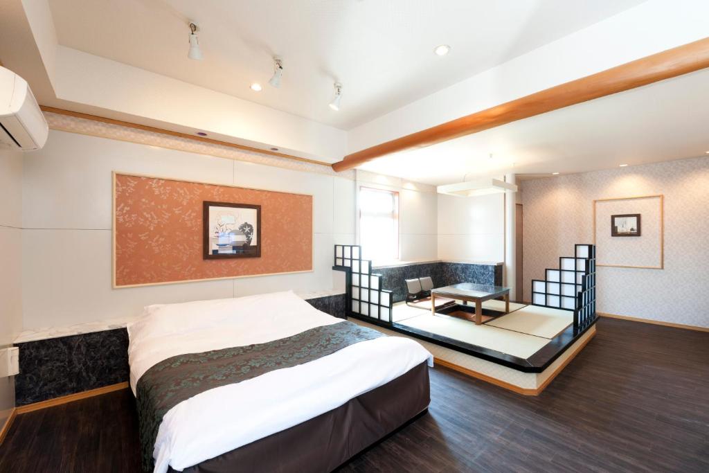 a bedroom with a bed and a desk in it at Hotel Fine Izumo Airport (Adult Only) in Izumo