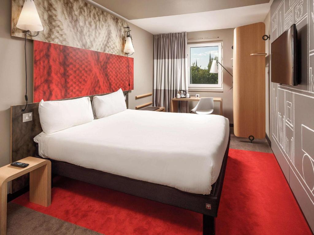 um quarto de hotel com uma cama grande e uma televisão em ibis Coventry Centre em Coventry