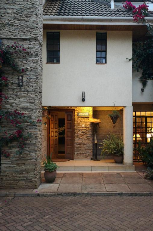un edificio in mattoni con una porta e piante di fronte di Hob House a Nairobi