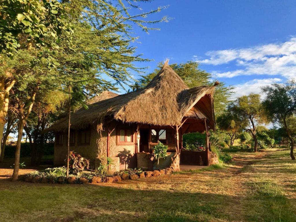 uma pequena casa com telhado de palha em Amboseli Eco Camp em Amboseli