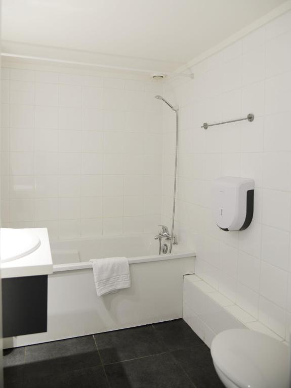 a white bathroom with a sink and a toilet at Aerel Hotel Aéroport Blagnac in Blagnac