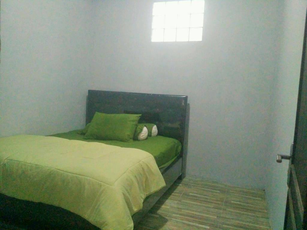 a small bedroom with a bed and a window at Homestay Bumi Asri III Cikutra in Bandung