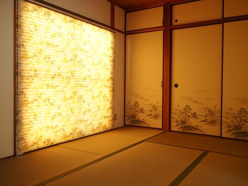una habitación vacía con puertas de cristal y una pared en Lumiere De Bonnart en Okayama