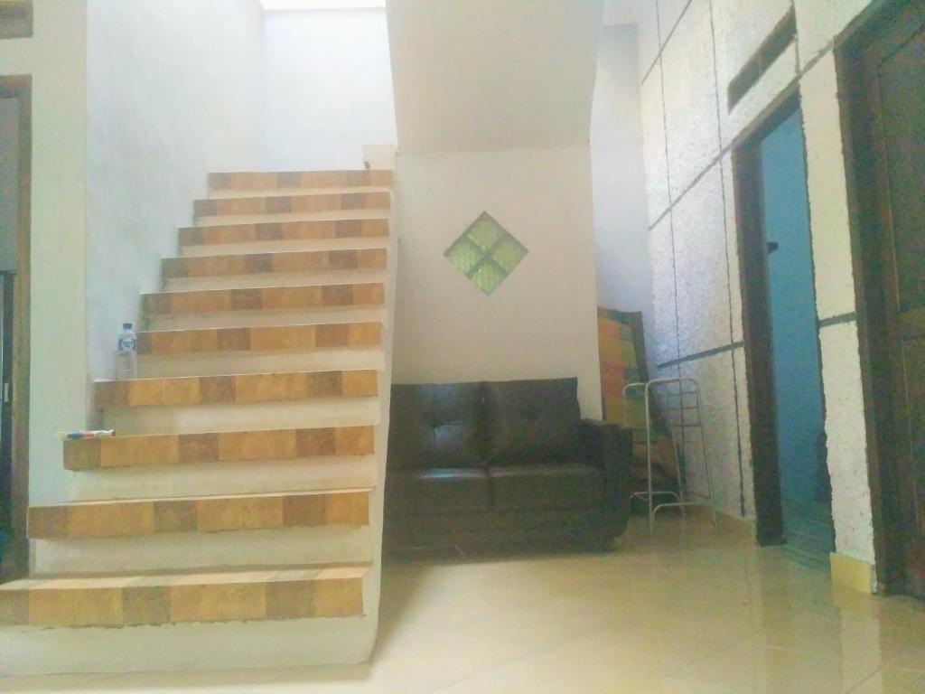 a staircase in a living room with a couch at Homestay Bumi Asri III Cikutra in Bandung