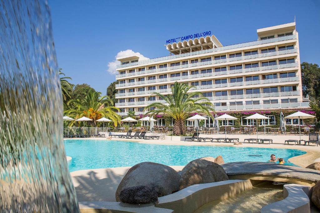 a hotel with a swimming pool in front of a building at Hôtel Campo Dell'oro in Ajaccio