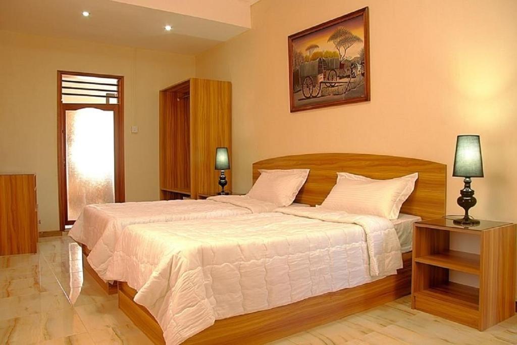 a bedroom with a large bed with white sheets at Auberge Le Rajah in Quatre Bornes