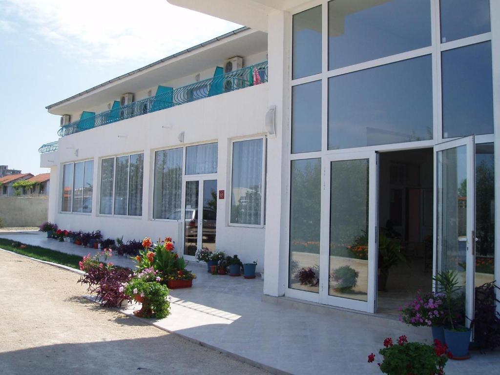 a white building with a lot of windows and flowers at Sani Family Hotel in Byala