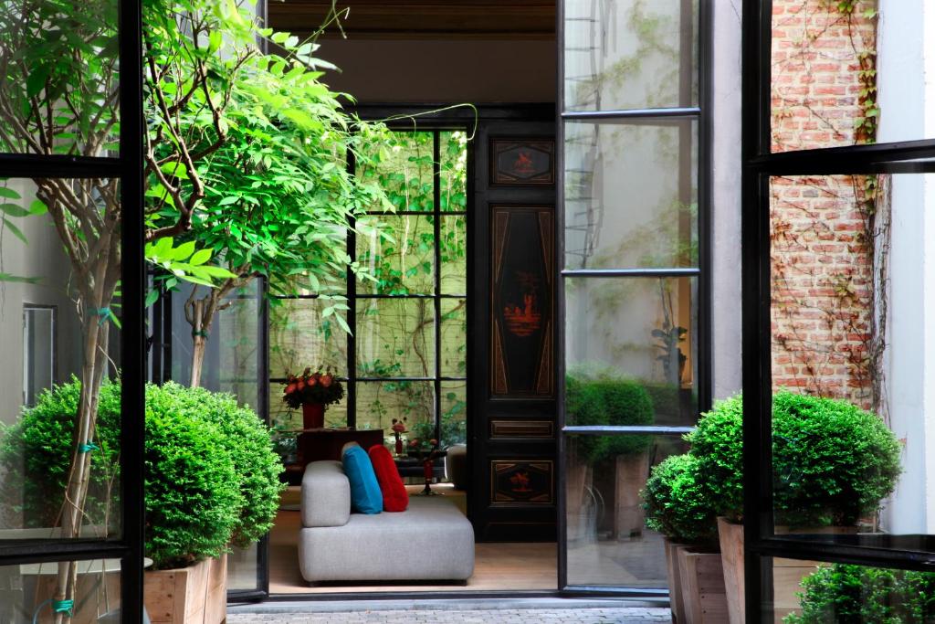 an open door to a patio with a couch and plants at Hotel Julien in Antwerp