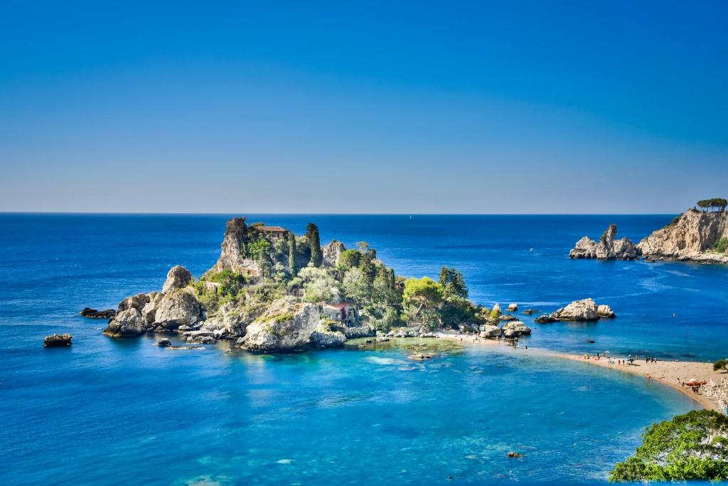 une île dans l'océan avec des rochers dans l'eau dans l'établissement Cohen Smart House, à Taormine