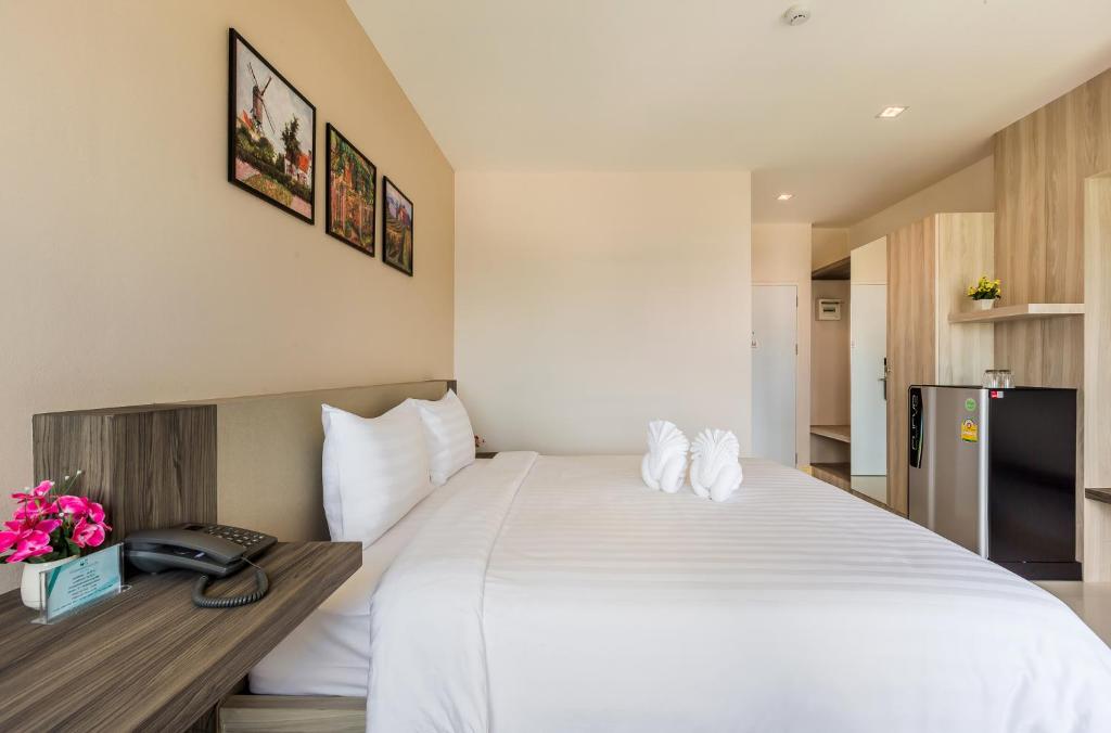 Postel nebo postele na pokoji v ubytování Evergreen Suite Hotel