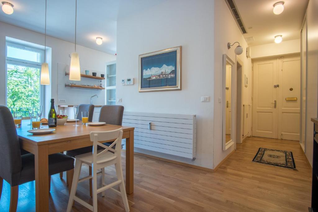 - une salle à manger et un salon avec une table et des chaises en bois dans l'établissement Luxury Central Apartment, à Ljubljana