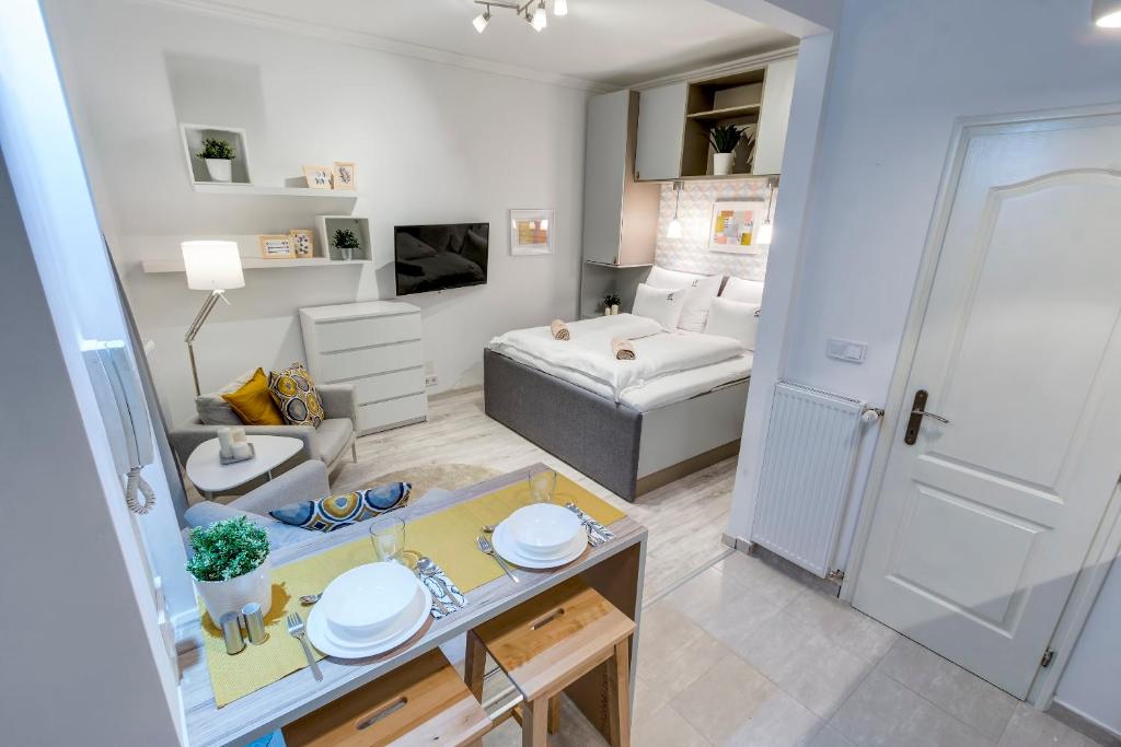 een kleine woonkamer met een bed en een tafel bij d.Five Riverside Deluxe Apartment in Boedapest