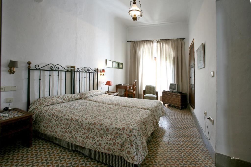 a bedroom with a large bed and a window at Posada de Palacio in Sanlúcar de Barrameda