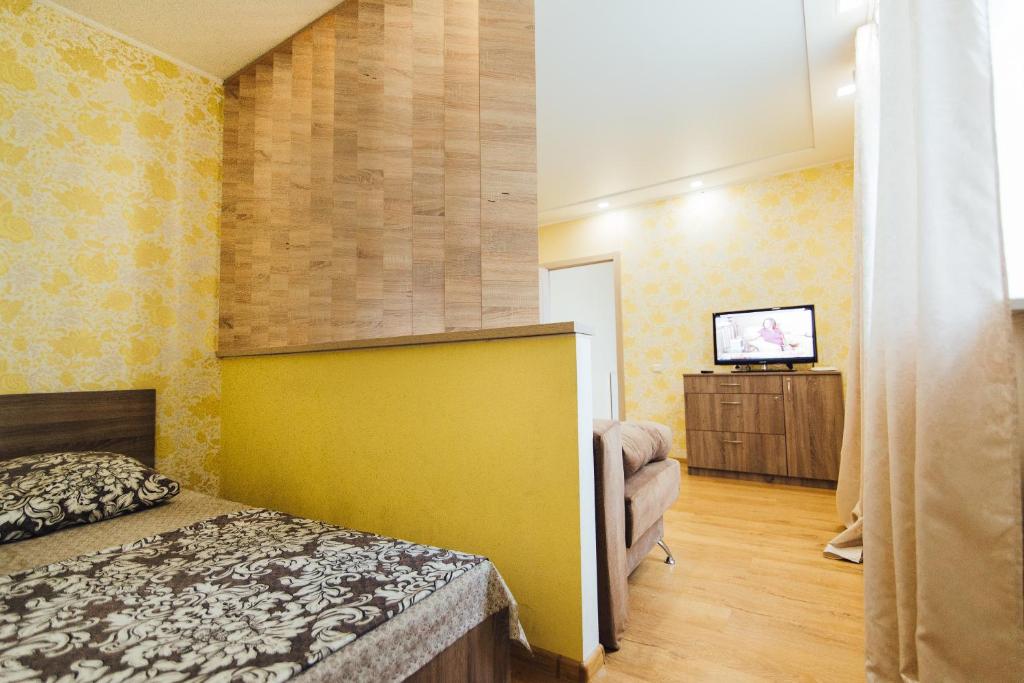 a bedroom with a bed and a tv in a room at Apartments Faraon in Sumy