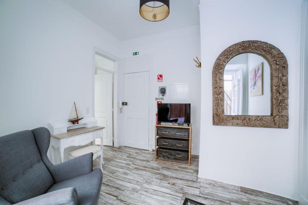 - un salon avec un canapé et un miroir dans l'établissement Garden Apartment, à Lisbonne