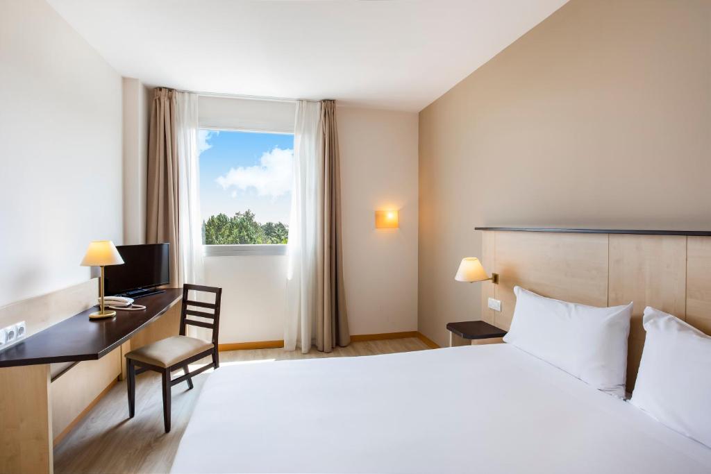 a hotel room with a bed and a desk and a window at B&B HOTEL Madrid Pinar de las Rozas in Las Rozas de Madrid