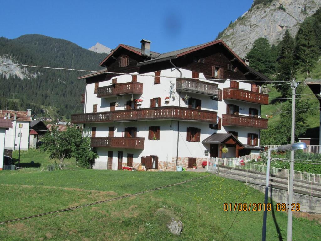 un gran edificio blanco con balcones en una montaña en Ciesa Dei Maestri, en Sottoguda