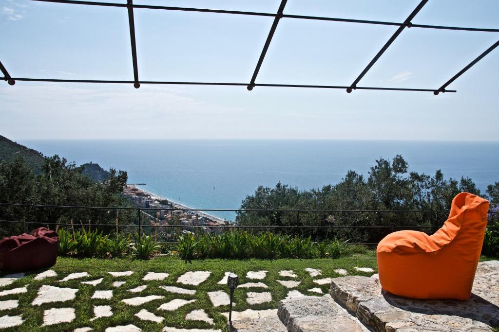 une paire de chaises orange assises au-dessus d'une pelouse dans l'établissement Casa vacanze A lea l'ua, à Finale Ligure