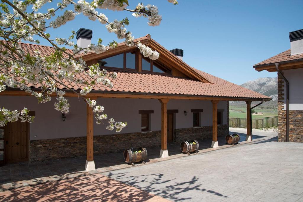 una casa con un árbol floreciente delante de ella en La Morada de Andoin, en Andoín