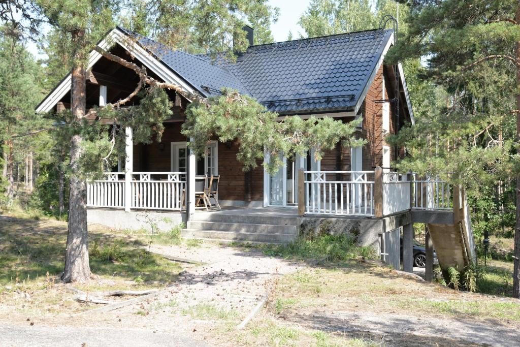 a log home with a porch and stairs to the front door at Mäntykallio in Loviisa