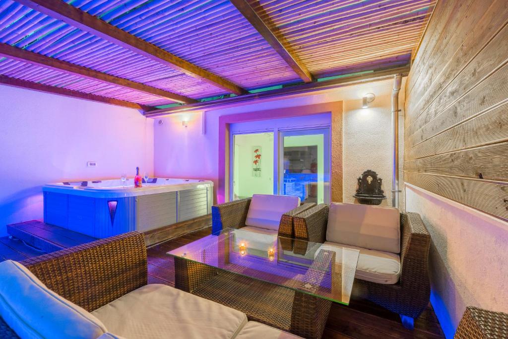 sala de estar con iluminación púrpura y bañera en Alena Luxury apartment with jacuzzi, en Split