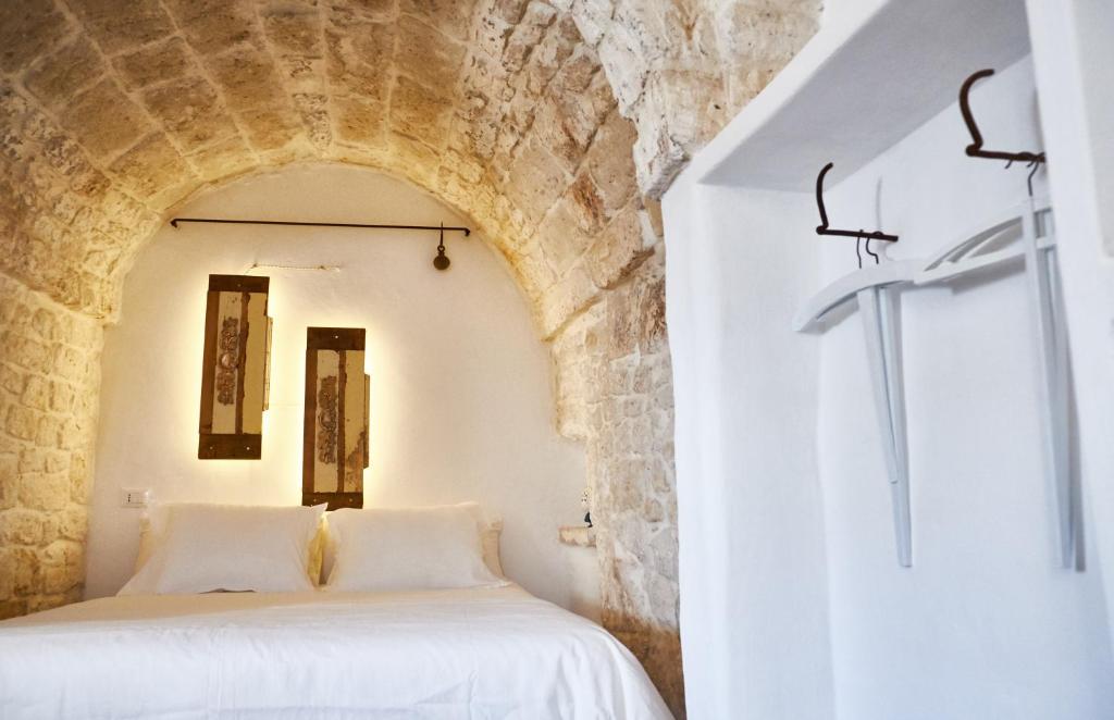 een slaapkamer met een wit bed in een stenen muur bij White Dream in Ostuni