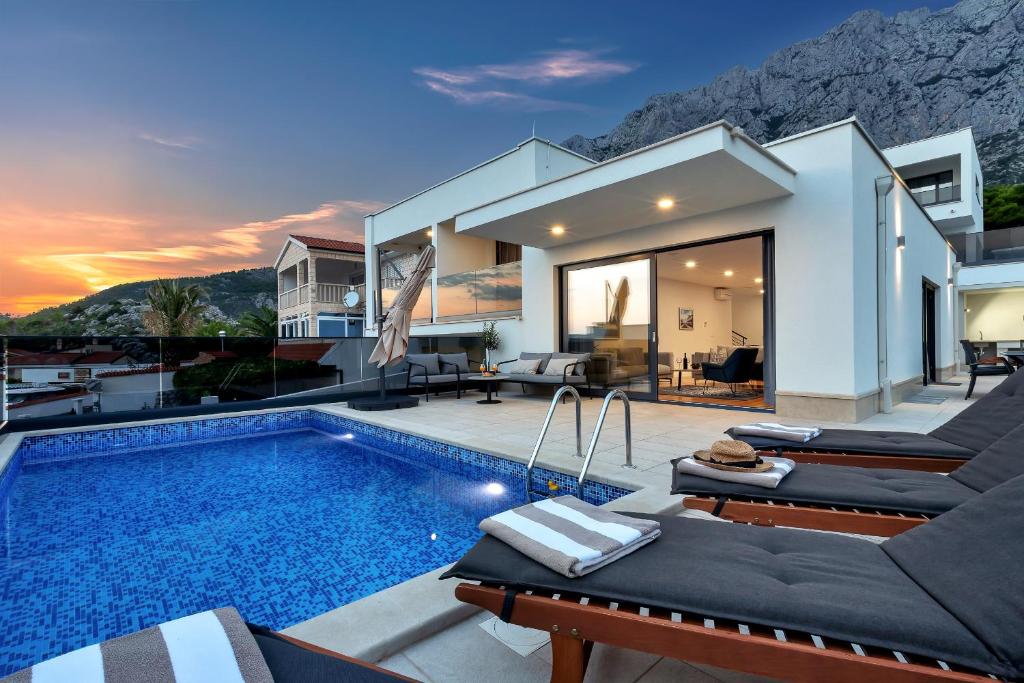 a villa with a swimming pool and a house at Villa Mendula in Makarska