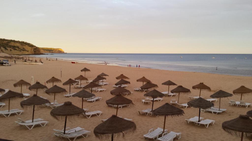 a group of umbrellas and chairs on a beach at Casa Praia Mar in Salema