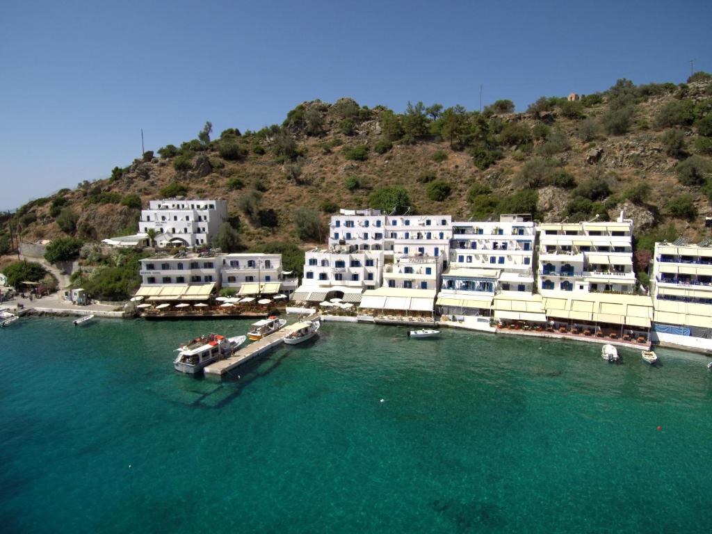 a group of white buildings sitting on top of a body of water at Αnna in Loutro