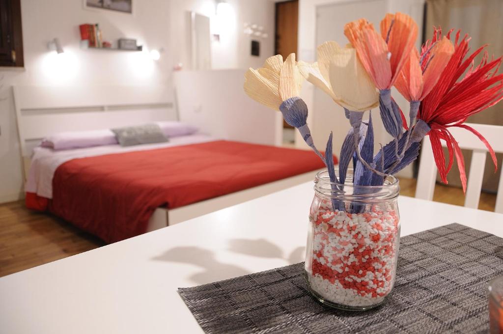 パレルモにあるArgo's Apartmentのテーブルとベッドの上に花が飾られた瓶