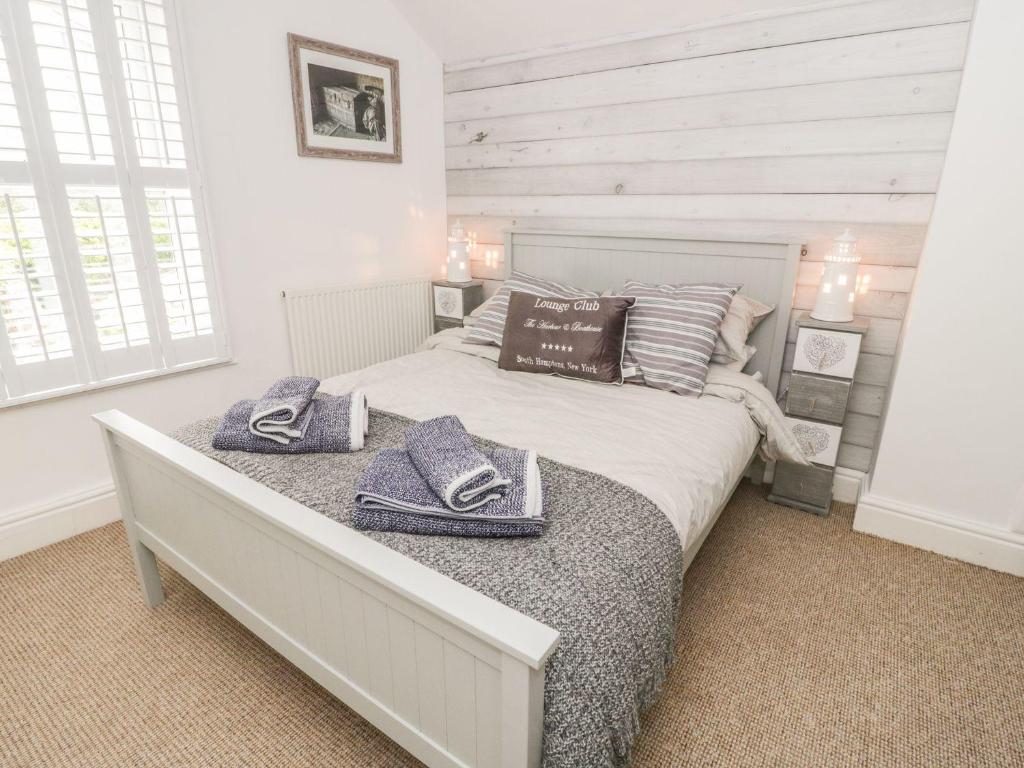 a bedroom with a bed with two towels on it at Sefton Cottage in Deganwy
