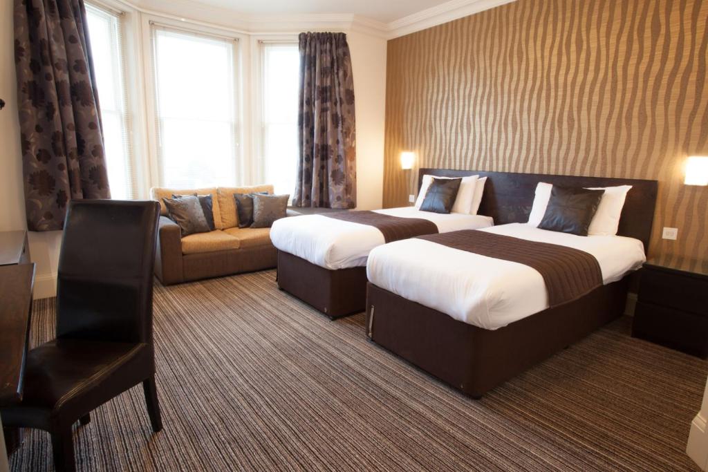 a hotel room with two beds and a couch at The Hop Inn in Bournemouth